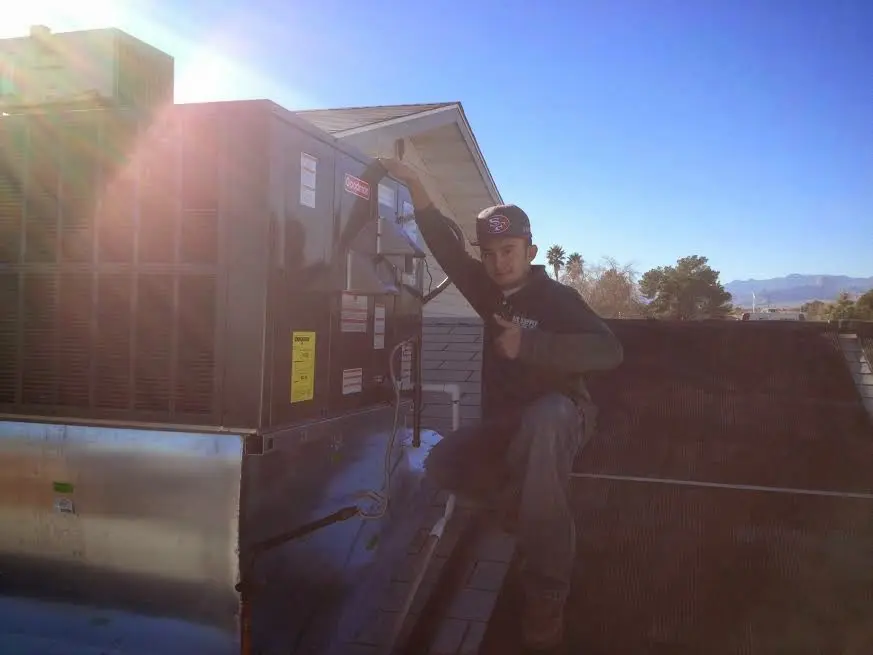 HVAC technician performing Boiler Repair on a rooftop unit in Moses Lake